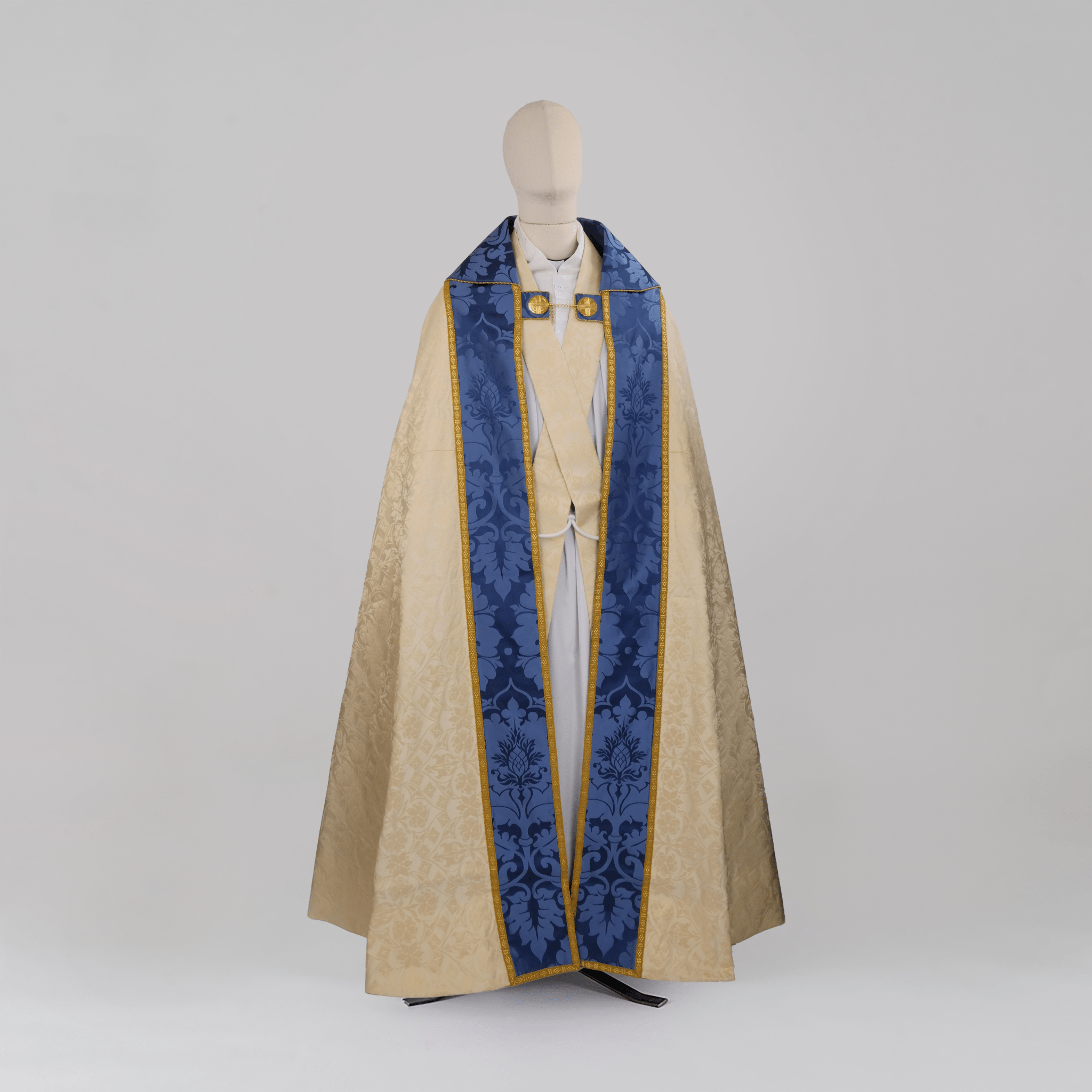 Minster Cope in Cream 'St John' Damask with Blue 'Bellini' Orphreys and Lamb of Gold Embroidered Hood - Watts & Co.