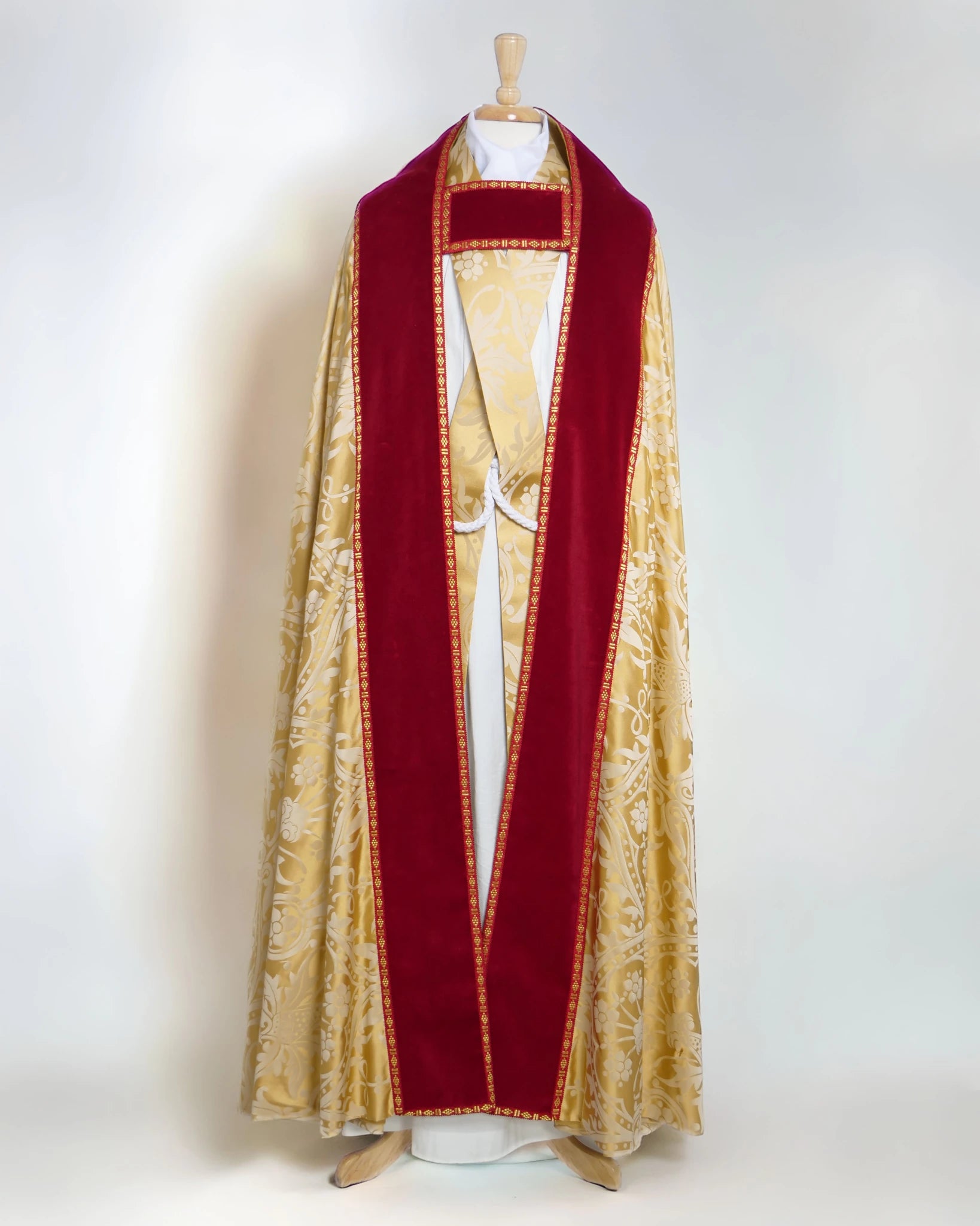Westminster Cope in Gold/Cream 'Shrewsbury' with Berry 'Venice' Velvet orphreys and an IHS Hand - Embroidered Hood - Watts & Co.