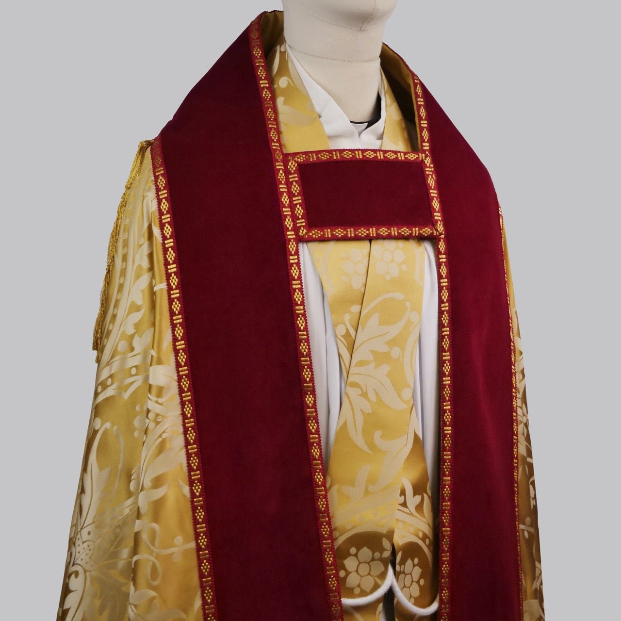 Westminster Cope in Gold/Cream 'Shrewsbury' with Berry 'Venice' Velvet orphreys and an IHS Hand - Embroidered Hood - Watts & Co.