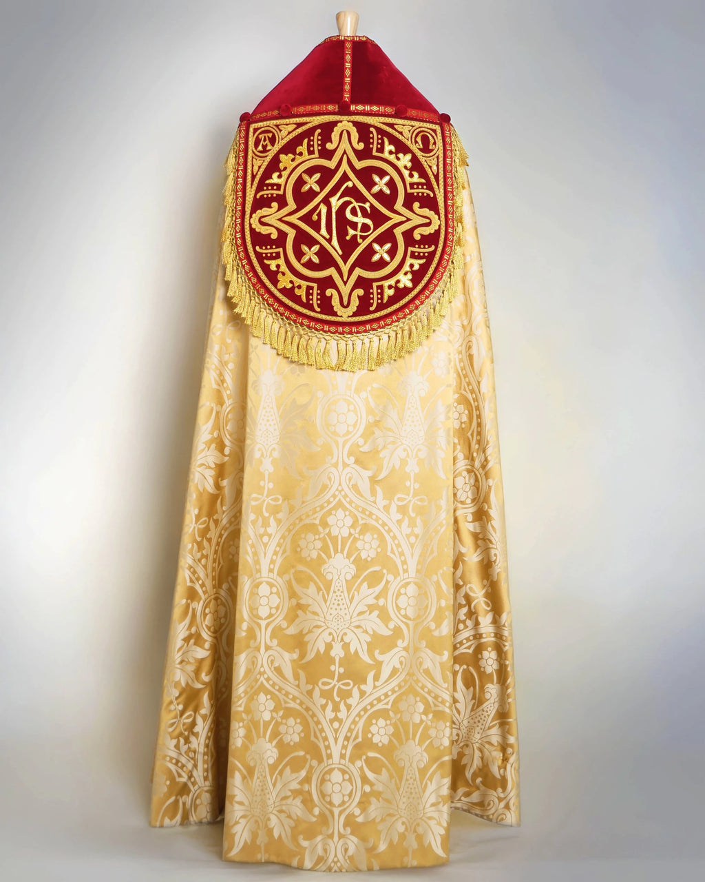 Westminster Cope in Gold/Cream 'Shrewsbury' with Berry 'Venice' Velvet orphreys and an IHS Hand - Embroidered Hood - Watts & Co.