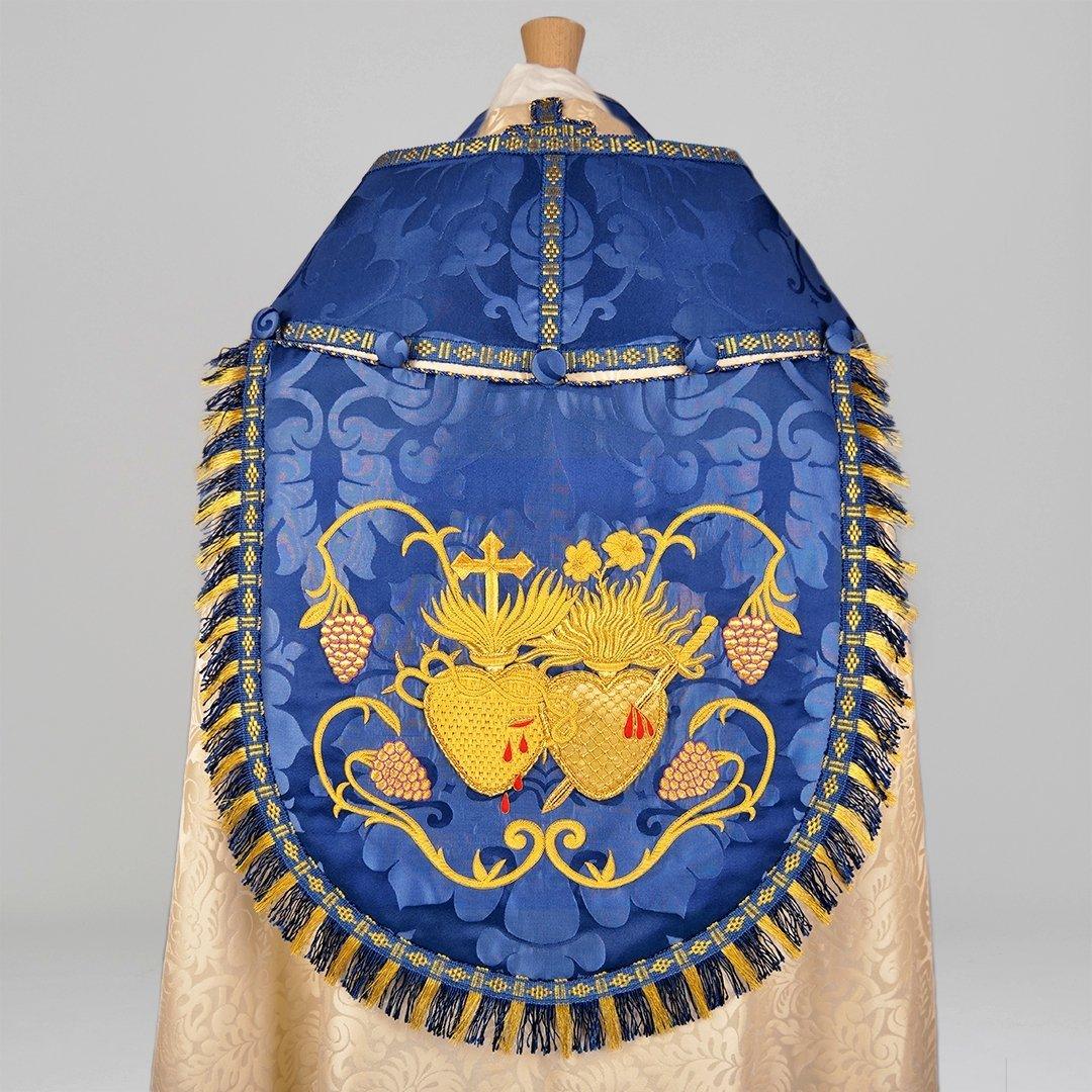 Minster Cope in Cream 'Holbein' with Blue 'Bellini' Orphreys and Sacred/Immaculate Heart Embroidered Hood - Watts & Co.